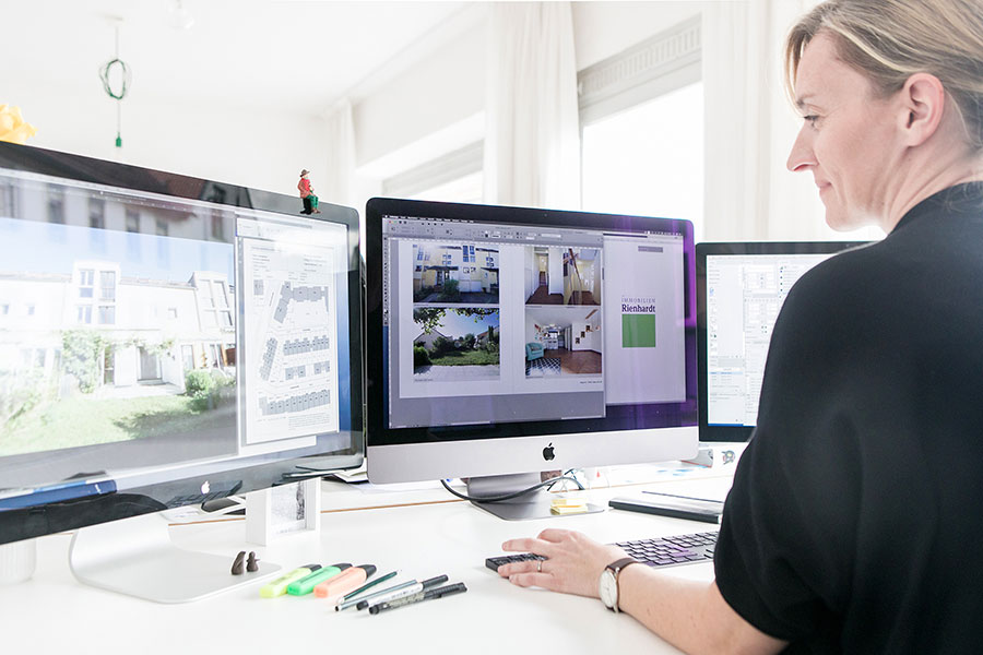 Jessica Widmaier sitzt vor ihrem Computer und arbeitet am Layout eines Immobilien-Exposés